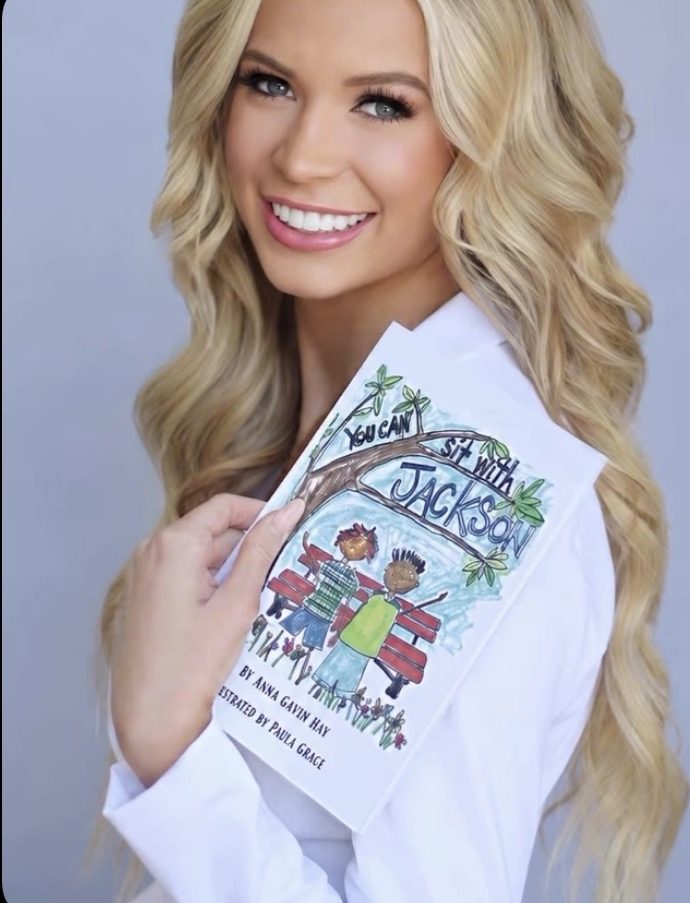 Anna Claire Hay holding her children's book You Can Sit With Jackson
